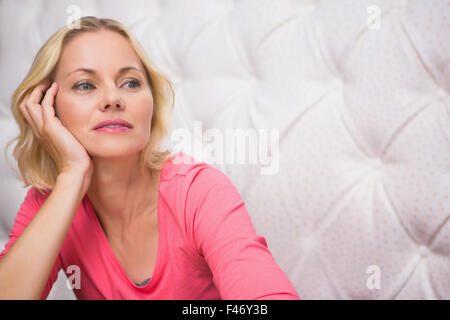 Hübsche Blondine sitzen und denken Stockfoto