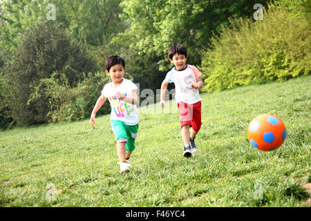 Jungs spielen Fußball im Feld Stockfoto