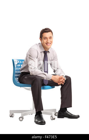 Vertikale Aufnahme eines freudigen Geschäftsmann auf dem blauen Stuhl sitzend und mit Blick auf die Kamera isoliert auf weißem Hintergrund Stockfoto