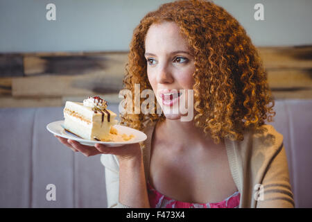 Gerne hübsche Brünette zeigt einen Kuchen Stockfoto