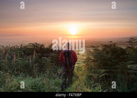 Walker, genießen das Schauspiel der aufgehenden Sonne brennen durch Nebel Teesdale, County Durham UK Stockfoto