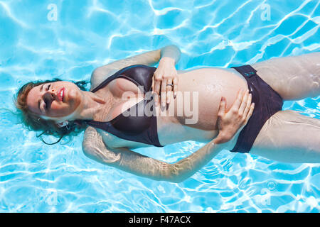 SCHWANGERE FRAU IN EINEM POOL Stockfoto