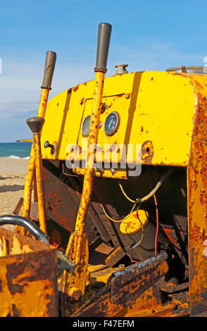 Die Steuerelemente eine alte Arbeit gelbe Raupe Traktor am Strand von Cley-Next-the-Sea, Norfolk, England, Vereinigtes Königreich. Stockfoto