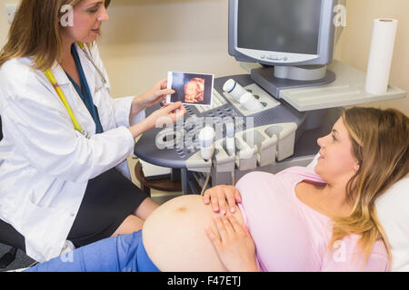 Arzt zeigt Bild, die schwangere Frau Stockfoto