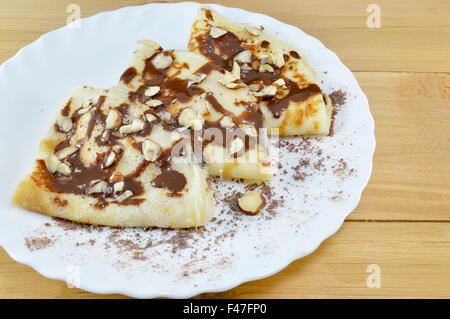 Hausgemachte süße Pfannkuchen mit Schokolade und Haselnüssen Omlett auf der Platte bedeckt Stockfoto