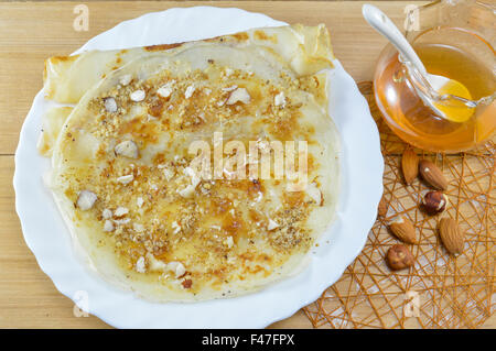 Süße Pfannkuchen mit Honig und Haselnüssen auf den weißen palte Stockfoto