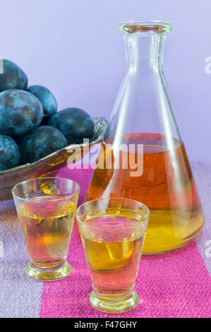 Plum Schnaps und frischen Pflaumen serviert auf der Tischdecke Stockfoto