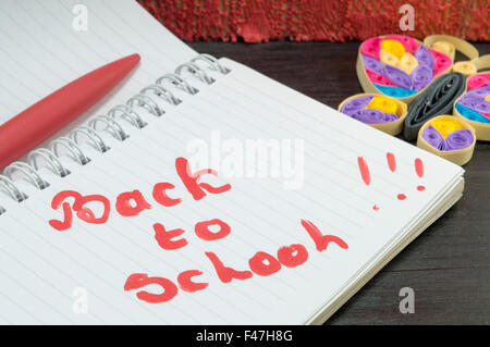 Zurück zur Schule geschrieben auf einem Notebook mit Papier Schmetterling verziert Stockfoto