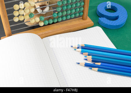 Lernen das Kalkül. Alte Rechner blaue Nummer 9 und Stifte auf dem Notebook-Papier Stockfoto