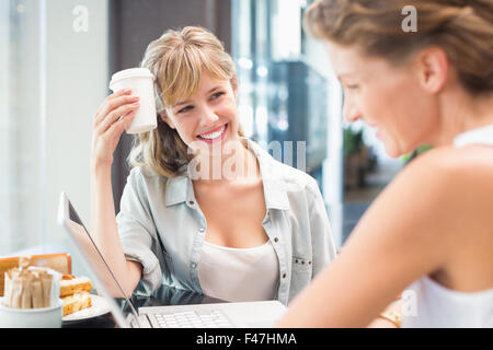 Schöne Frau hält Kaffee und Freund betrachten Stockfoto