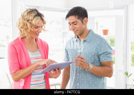 Kolleginnen und Kollegen stehen und Tablet-Computer gemeinsam nutzen Stockfoto