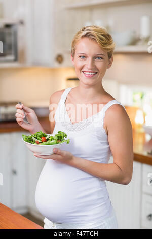 Schwangere Frau, die einen frischen Salat essen Stockfoto