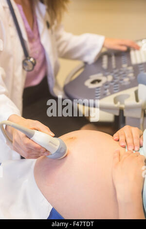 Herr Doktor Scan schwangeren Patientin Bauch Stockfoto