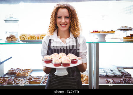 Gerne hübsche Barista Halteplatte mit Kuchen Stockfoto