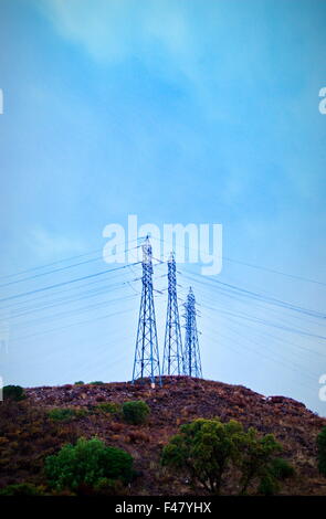 Elektrische Leistung Pylon und Drähte, die Silhouette von blauen Morgenhimmel kurz vor Sonnenaufgang Stockfoto