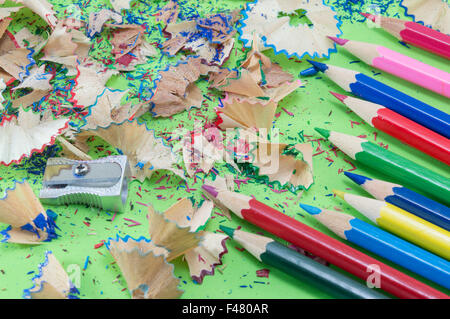 Bunte Bleistifte und schärfen Reste auf grünem Hintergrund Stockfoto