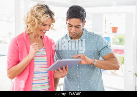Kolleginnen und Kollegen stehen und Tablet-Computer gemeinsam nutzen Stockfoto