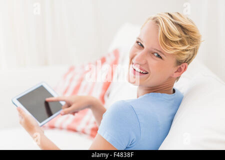 Porträt der lächelnde Frau sitzt auf der Couch und Tablettcomputer Stockfoto