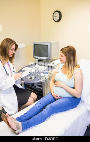 Arzt im Gespräch mit schwangeren Patientin Stockfoto