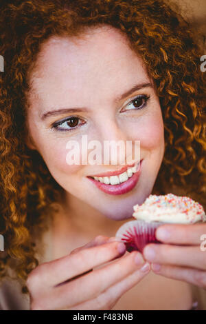 Porträt einer glücklich hübschen Frau einen Kuchen essen Stockfoto