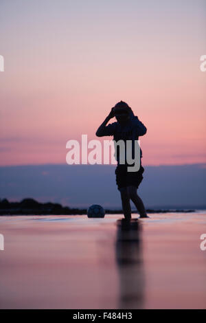 Ein Teenager, waten im Ozean, Skane, Schweden. Stockfoto