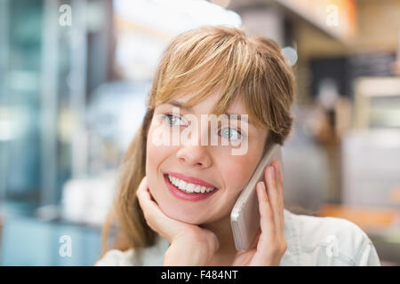 Schöne Frau, lächelnd und mit einem Telefonanruf Stockfoto