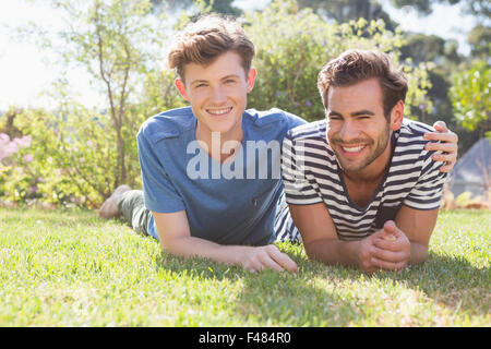Glückliche homosexuelle Paar auf dem Rasen liegen und Blick in die Kamera Stockfoto