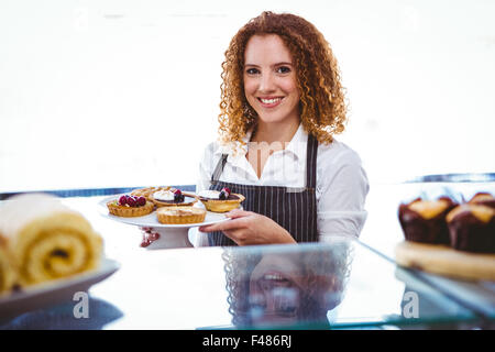 Hübsche Frau Halteplatte mit Kuchen Stockfoto