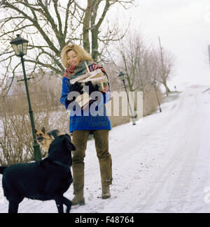 Skandinavische Frau mit Hunden im Schnee, Schweden. Stockfoto