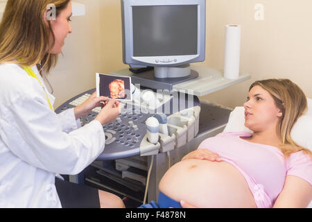 Arzt zeigt Bild, die schwangere Frau Stockfoto