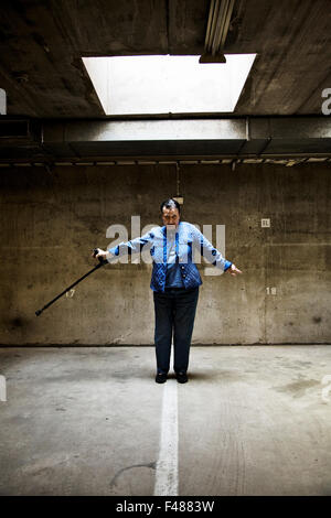 Frau posiert mit einem Stock in einer Garage, Finnland. Stockfoto