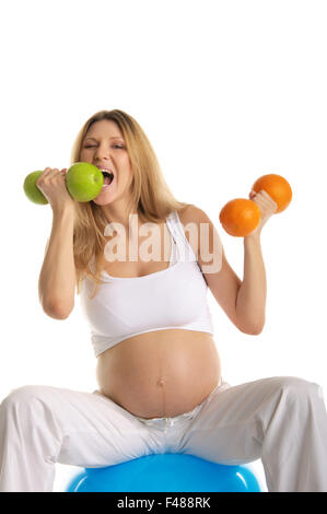 Schwangere Frau beißt Hantel Obst Stockfoto