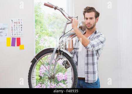 Nachdenkliche, gut aussehender Mann mit seinem Fahrrad Stockfoto