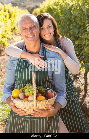 Lächelnde paar Holding Korb mit Früchten Stockfoto