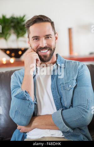 Sitzt gut aussehender Mann in die Kamera schaut Stockfoto