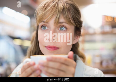 Schöne Frau Kaffee trinken und wegsehen Stockfoto