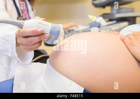 Herr Doktor Scan schwangeren Patientin Bauch Stockfoto