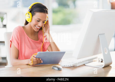 Glücklich kreative Geschäftsfrau Musik hören mit ihrem Tablet-PC Stockfoto