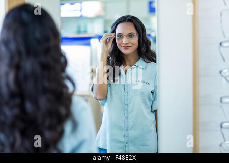 Schöne Brünette, die sich selbst im Spiegel betrachten Stockfoto