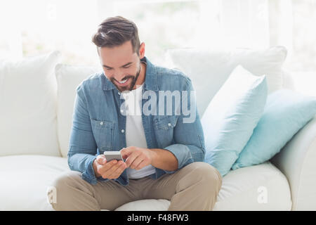 Lächelnder Mann senden einer Textnachricht Stockfoto
