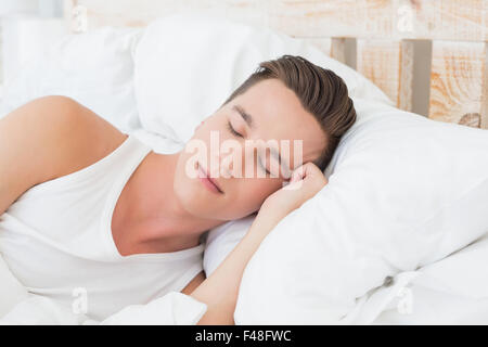 Gut aussehender Mann schläft auf Bett Stockfoto