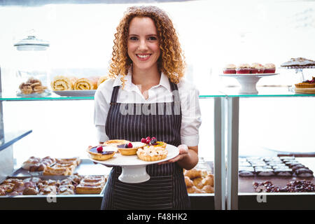 Gerne hübsche Barista Halteplatte mit Kuchen Stockfoto