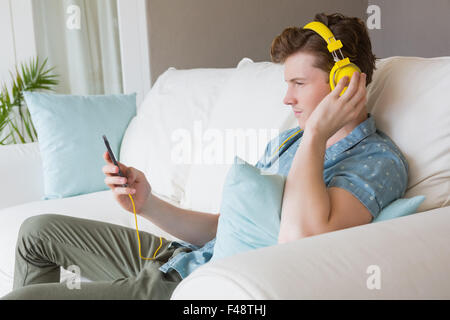 Hübscher junger Mann Musik hören mit Kopfhörern Stockfoto