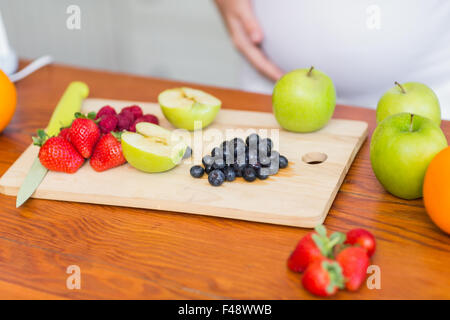 Schwangere Frau bereitet einen Obstsalat Stockfoto