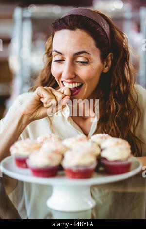 Hübsche Brünette Blick auf Kuchen Stockfoto