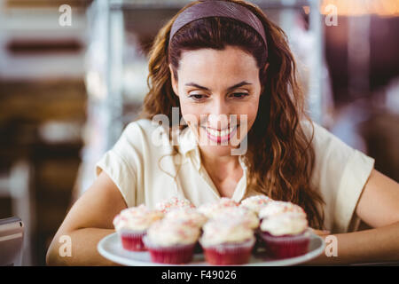 Hübsche Brünette Blick auf Kuchen Stockfoto