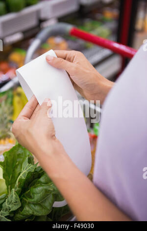 Frau liest ihre Einkaufsliste Stockfoto