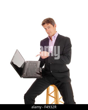 Business-Mann zeigt auf Laptop. Stockfoto