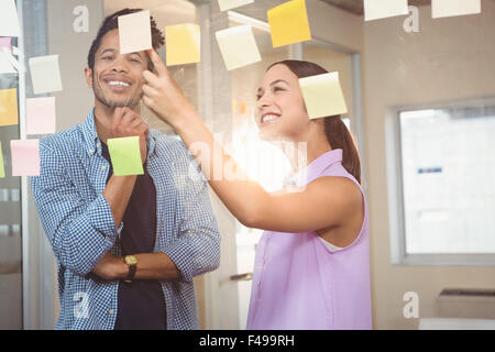 Glücklich Geschäftsfrau zeigt auf Haftnotizen Stockfoto