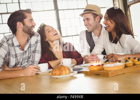 Kaffee und Leckereien genießen Freunde lachen Stockfoto